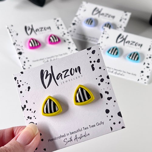 Triangular earrings with black and white striped design on Blazon Jewellery cards.